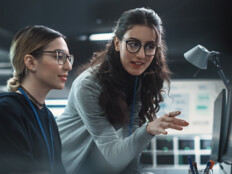 two IT leaders discuss cybersecurity in front of computer